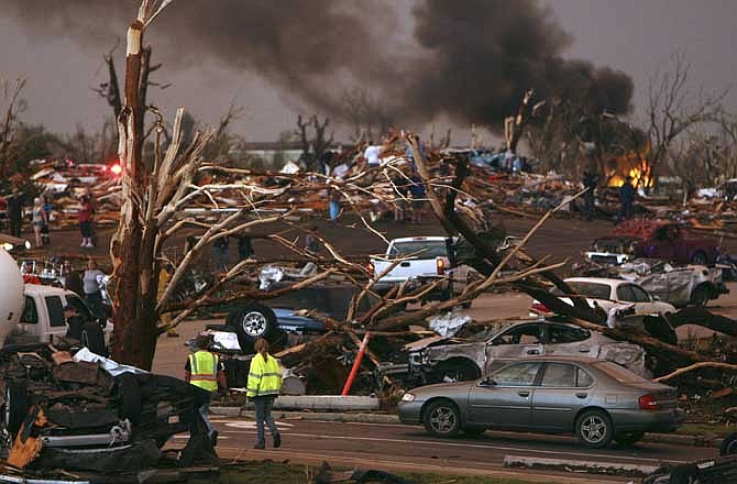 Emergency personnel walk through a neighborhood severely damaged by a tornado near the Joplin Regional Medical Center in Joplin, Mo., Sunday, May 22, 2011. A large tornado moved through much of the city, damaging a hospital, schools and hundreds of homes and businesses. 