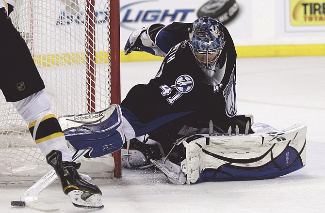 Lightning goalie Mike Smith reaches for the puck during Saturday's win over the Bruins in Tampa, Fla. 