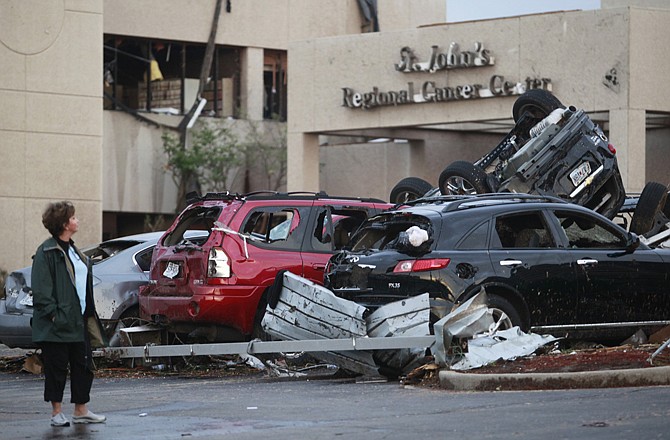 A woman looks at the damage to St. John's Regional Medical Center in Joplin a day after it was hit by a tornado.