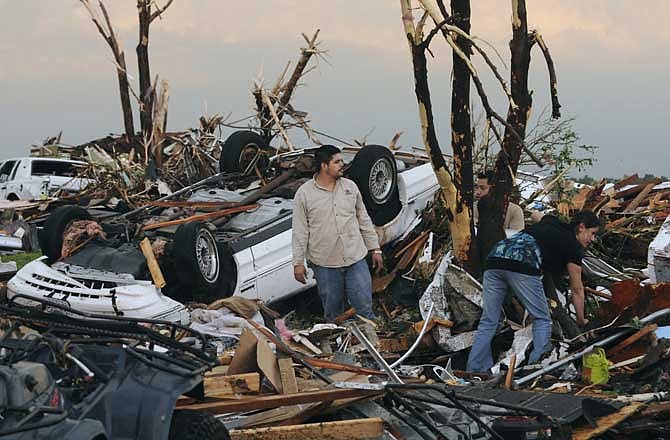 Residents begin digging through the rubble of their home after it was destroyed by a tornado that hit Joplin, Mo. on Sunday evening, May 22, 2011. The tornado tore a path a mile wide and four miles long destroying homes and businesses.