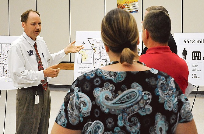 Eric Schroeter, interim district engineer, left, explains how the Missouri Department of Transportation hopes to save more than $512 million during a lightly-attended community meeting Monday evening at Lewis and Clark Middle School.