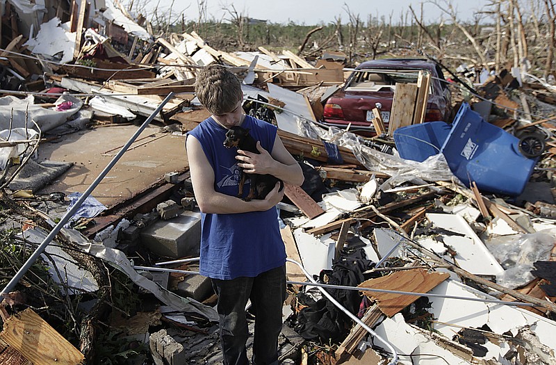 Tyler Taylor is reunited with his dog Lilly in his tornado-damaged home in Joplin. Lilly had been missing until Tuesday.