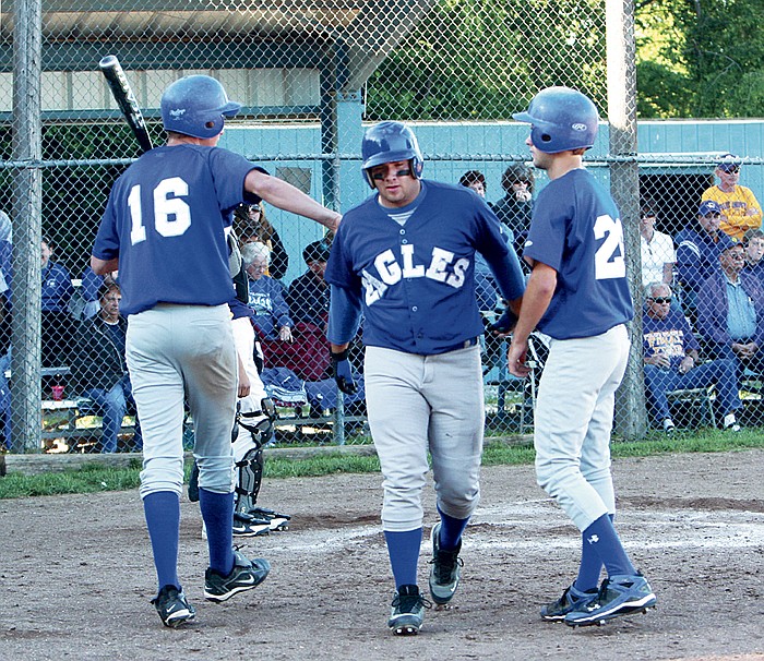 Jamestown's Chad Cook, center, is congratulated by teammates Seth Rohrbach (16) and Andy Flippin (29) on his second homerun of the night during the sixth nning of the Eagles' Class 1 District 11 semifinal game against Pilot Grove.