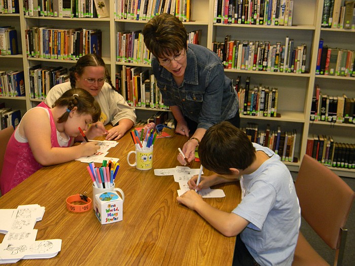 Wood Place Public Library Director Connie Walker helps with the crafts at the Summer Reading Program Registration held Saturday, May 21.
