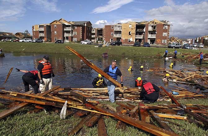 Members of the Newton County (Mo.) Rescue and Recovery team clear debris from a pond next to an apartment complex so they can search for potential victims in Joplin, Mo., Wednesday, May 25, 2011. At least 125 people were killed and hundreds more injured when a tornado cut a destructive path through Joplin on Sunday evening. 