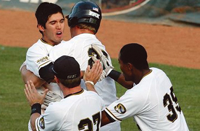 Missouri's Eric Garcia, middle, is mobbed by teammates after getting the game-winning hit in the ninth inning of Thursday's Big 12 Tournament game against Oklahoma State.