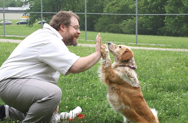 Ceree gives her handler, Joseph Zelk, a high-five on Thursday at Cremer Therapeutic Community Center. Ceree recently came to the center as a therapeutic house dog for the offenders.