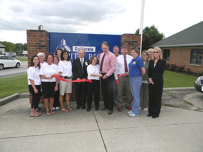 Members of the California Area Chamber of Commerce, family and friends help Capital Region Medical physicians Dr. Jan Finney and Dr. Todd McCluskey cut the ribbon on their new partnership.