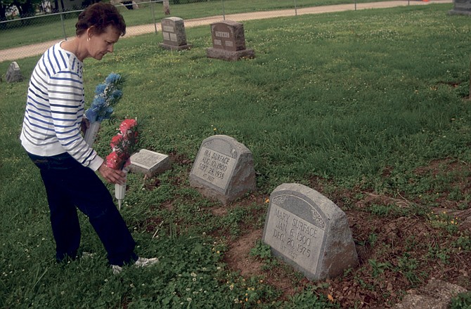 Carolyn Nichols, of Eldon, Mo., places flowers on her grandparents' graves Monday, May 23, 2011, in Elston, Mo. Nichols, who grew up in Elston, has been instrumental in establishing the Friends of Elston Cemetery group after an acquaintance mentioned last year that it was in disrepair. Elston is just north of St. Martins on Route T.