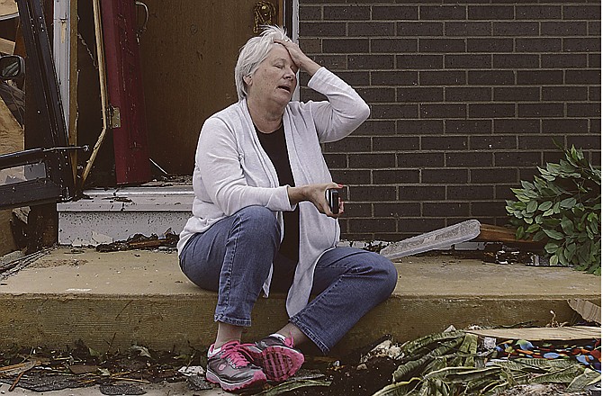 Shirley Waits sits outside her mother's home and waits for an insurance adjuster to arrive in Joplin, Mo. A massive tornado moved through Joplin last Sunday, leveling much of the city. 