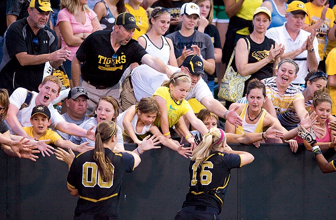 Missouri teammates Rachel Hay (left) and Megan Christopher are congratulated by fans along the fence after Sunday night's 6-3 Super Regional win over Washington at University Field in Columbia.