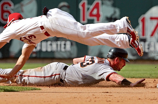 Aaron Rowand of the Giants gets safely back to second as Cardinals shortstop Ryan Theriot dives for the ball thrown by catcher Yadier Molina during the fifth inning of Monday afternoon's game at Busch Stadium.
