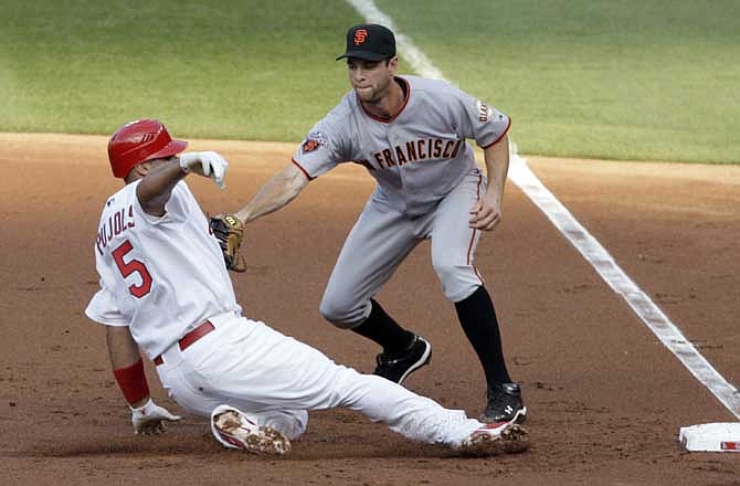 St. Louis Cardinals' Albert Pujols (5) is tagged out by San Francisco Giants first baseman Brandon Belt as he slides into first after trying to stretch his single in the first inning of a baseball game, Tuesday, May 31, 2011, in St. Louis.