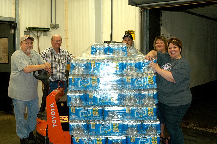 Loading a Hogans truck at the Cargill Hatchery in California are, from left, Wayne Rex, Dan Britton, Walter Phipps, Julie Gerloff and Ronnie Korte. Supplies were collected from around the area at the hatchery and the Cargill processing plant. The Hogan's truck stopped at Versailles to pick up items collected by the Ministerial Alliance. Two Joplin area turkey farm suppliers of Cargill were reported destroyed although most of the turkeys survived. 