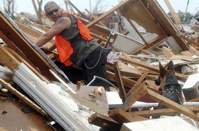 Parrish Evans, from Diamond Mo., calls to his rescue dog Jody as he searches for bodies at Greenbriar Nursing Home in Joplin, Mo. on Tuesday May 24, 2011. Police, firefighters, medical and other emergency workers have come from all over the state and nation to volunteer in search, rescue and cleanup efforts.