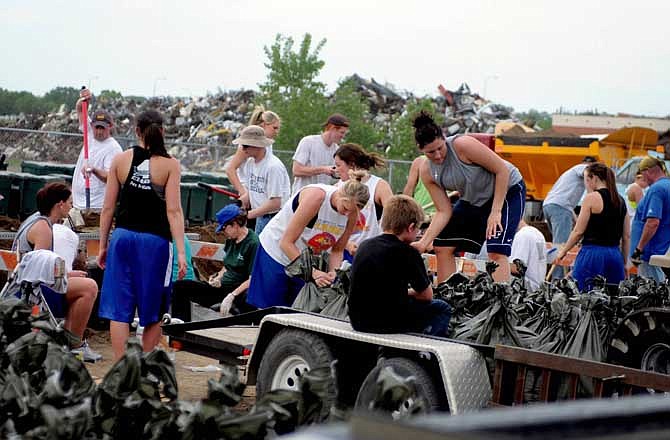 UPSTREAM FLOODING: Members of the South Dakota State University athletic teams help sandbag in Pierre, S.D., on Thursday, June 2, 2011. The U.S. Army Corps of Engineers is increasing releases from Oahe Dam to dump water from heavy rains upstream. The Missouri River continues to threaten flooding from South Dakota to Missouri. (AP Photo/Capital Journal, Chris Mangan)