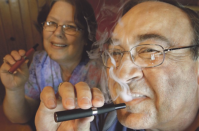 In this May 31, 2011 photo, Cliff Phillips, a 61-year-old retiree and former smoker, and his wife, Vali, enjoy electronic cigarettes at their home in Cuba, Ill., Tuesday, May 31, 2011. Electronic cigarettes like the one used by Phillips are at the middle of a social and legal debate over whether it's okay to "light up" in places where regular smokes are banned.