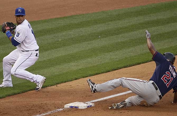 Minnesota Twins' Delmon Young (21) beats the tag at third base by Kansas City Royals third baseman Mike Aviles to advance on a single by Brian Dinkelman during the sixth inning of a baseball game, Saturday, June 4, 2011, in Kansas City, Mo. 