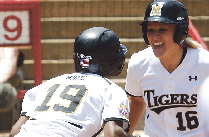 Missouri's Shana White, left, celebrates with teammate Megan Christopher, right, after scoring against Oklahoma in the second inning of an NCAA Women's College World Series softball game, Saturday, June 4, 2011, in Oklahoma City. Missouri won 4-1, but later lost to Baylor.