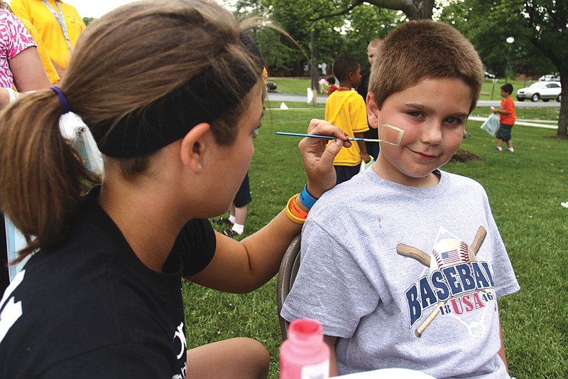 A student from the Missouri Association of Student Councils paints a child's face during the Free Children's Carnival held at William Woods University last year. This year's carnival will take place from 2-4 p.m. today in front of the Dome at WWU.