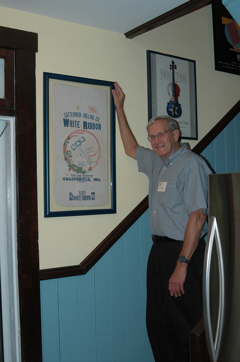 During the "Gala at the Mansion" held Saturday, June 4, J.D. Gattermeir admires a flour sack from his grandfather's mill in California. The flour sack is part of the collection of Rick and Pam Green which are used to decorate their 1898 mansion.