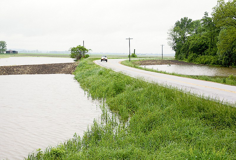 A SUV drives past pools of stagnant water on HWY 94 near Route O in Mokane during a previous year's flooding. 