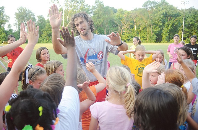 Lady Jays soccer coach Matt Stacey high-fives his summer camp participants during a session Thursday at the 179 Soccer Park. 
