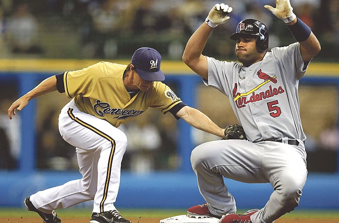 St. Louis Cardinals' Albert Pujols (5) slides into second base with a double as Milwaukee Brewers' Craig Counsell applies the late tag in the first inning of a baseball game on Saturday, June 11, 2011, in Milwaukee.