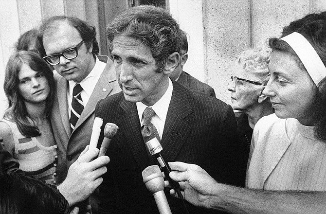 Daniel Ellsberg, with his wife, Patricia, at right talks to press in Los Angeles during a recess in his trial as his co-defendant Anthony Russo, and his wife, Katherine, listen at left. The two were charged in 1972 with the leak of top-secret documents to news media.