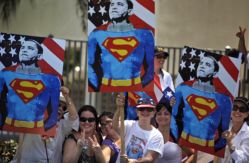 Supporters hold posters depicting President Barack Obama dressed as comic book superhero Superman as they wait Tuesday for the presidential motorcade to pass by in San Juan, Puerto Rico.