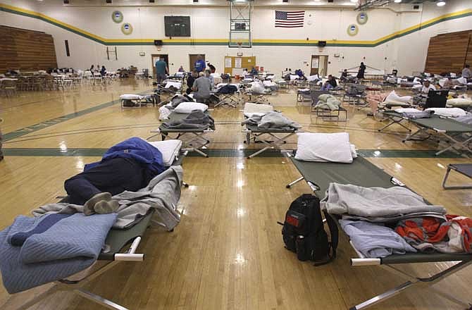 In this May 23, 2011, photo, an evacuee sleeps on a cot at a temporary American Red Cross shelter at the Robert Ellis Young Gymnasium at Missouri Southern State University in Joplin, Mo. The shelter is scheduled to close today (Tuesday, June 14), to be replaced by a smaller shelter.