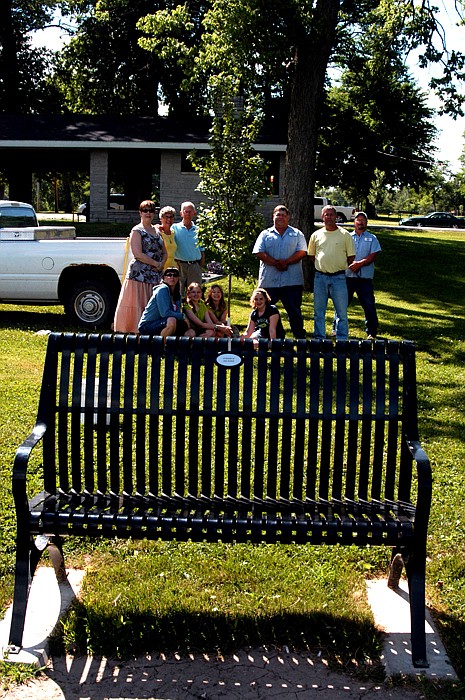 Present for the tree planting in memory of Opal Schwab on Saturday are, front row from left, Sandy (Schwab) Adams, Maggie Adams, Brooke Adams, Emma Baer; and standing, Suzanne Taggart, Jenice Taggart, Kelly Taggart, Chris Hughes, Mayor Norris Gerhart and Dave Decker. The tree is planted behind the bench in Schwab's memory. 