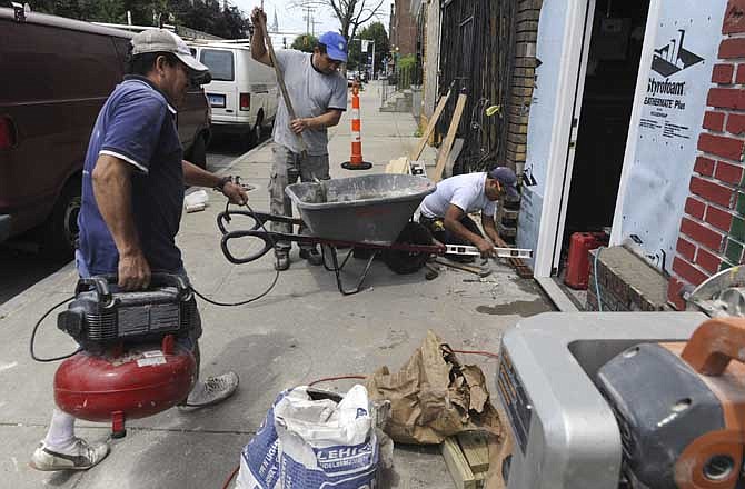 In this June 16, 2011 photo, workers repair a building that was damaged by a tornado a year ago, along East Main St. in Bridgeport, Conn. As the one-year anniversary approaches on June 24, recovery has been steady in some areas and lagging in others since since a tornado battered buildings and toppled trees in Connecticut's largest city.