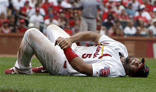 St. Louis Cardinals first baseman Albert Pujols grabs his left wrist after being injured on a play at first base during the sixth inning of an interleague baseball game against the Kansas City Royals Sunday, June 19, 2011, in St. Louis. Pujols left the game.
