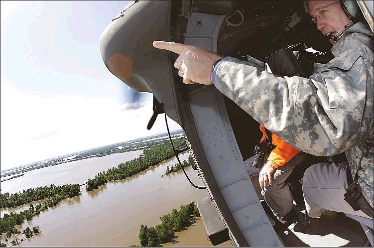 Gov. Jay Nixon points at floodwaters last month from a Missouri National Guard helicopter as he flies over floodwaters near the Birds Point levee over Mississippi County. Inset below, Nixon talks with President Barack Obama as they tour the devastation in Joplin. 