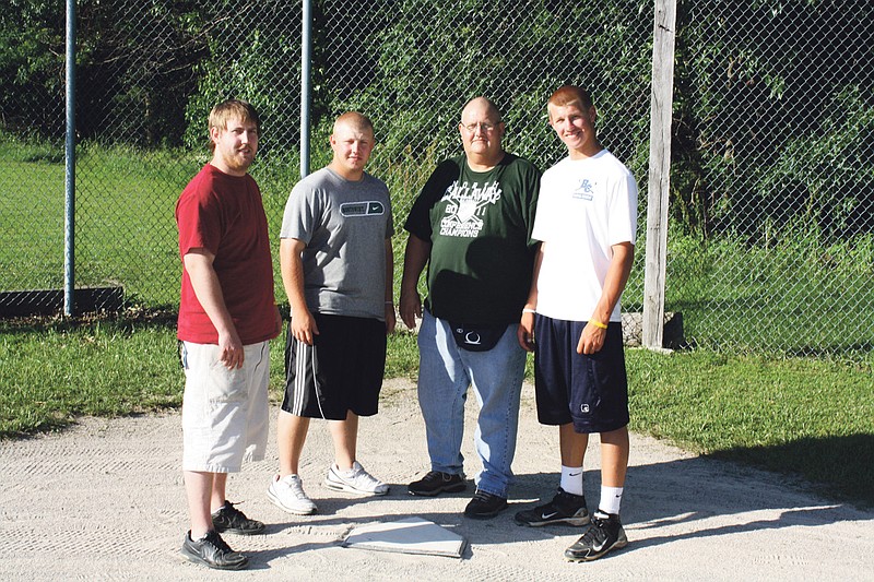 Denny Lavy (center) is joined by his son's Zane (far left), Zeth (near left) and Zach (right) at home plate of the family's baseball field located in the backyard of their home in Auxvasse. Denny was diagnosed with colon cancer last fall but fights the illness through treatment and a love of baseball. 