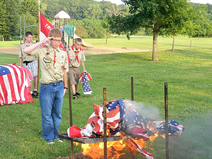 Co-Senior Patrol Leader Simon Schroeter (Life Scout), saluting after retiring an American flag.