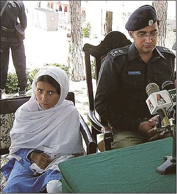 Sohana Jawed, left, a 9-year-old Pakistani girl, sits with police chief Salim Marwat after she was kidnapped on her way to school and forced to wear a suicide vest before escaping from her captors. 