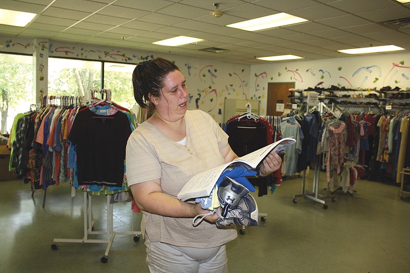 Melissa Flatoff of Fulton flips through a book for sale at the Kingdom Projects' re-sale store Wednesday. She purchased various items at the thrift shop. The store is open 8 a.m. to 2:30 p.m. Monday to Friday.