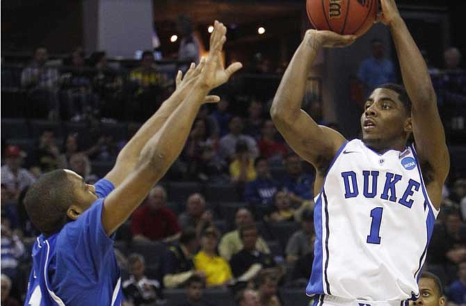 This March 18, 2011, file photo shows Duke guard Kyrie Irving (1) shooting over Hampton guard Mike Tuitt (11) in the second half of a West Regional NCAA tournament second round college basketball game, in Charlotte, N.C. Irving is a top prospect in the 2011 NBA draft. 