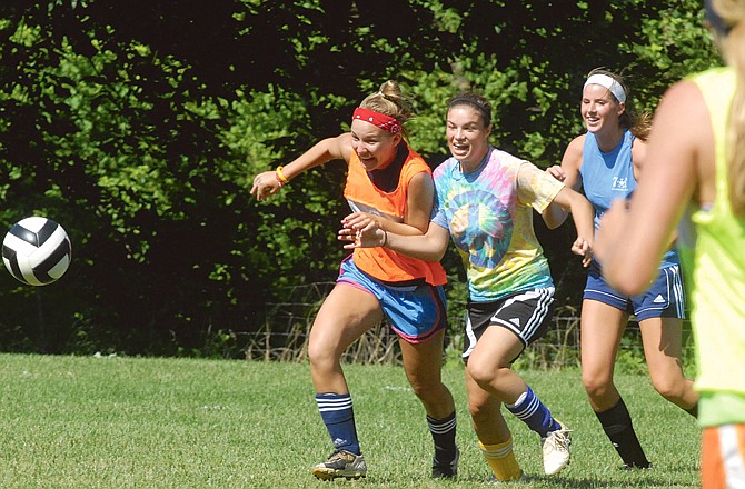 Members of the Helias girls soccer team chase after a loose ball Thursday at the 179 Soccer Park during the final day of the Lady Crusaders' summer camp.