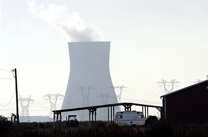 This Tuesday, Nov. 13, 2007 file picture shows a cooling tower at the Salem nuclear power plant owned by the Public Service Energy Group and a building on a small farm in Lower Alloways Creek Township, N.J., in rural Salem County. One of the highest known tritium readings was discovered in 2002 at the Salem facility. Tritium leaks from the reactor's spent fuel pool contaminated groundwater under the facility - located on an island in Delaware Bay - at a concentration of 15 million picocuries per liter. That's 750 times the EPA drinking water limit. According to NRC records, the tritium readings last year still exceeded EPA drinking-water standards. And tritium found separately in an onsite storm drain system measured 1 million picocuries per liter in April 2010.