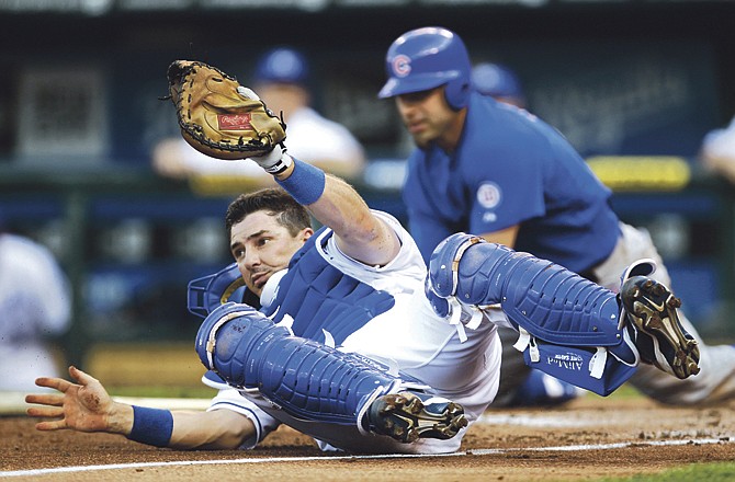 Kansas City Royals catcher Matt Treanor, left, hangs on to the ball after tagging out Chicago Cubs' Reed Johnson, behind, during the third inning of an interleague baseball game in Kansas City, Mo., Saturday, June 25, 2011.