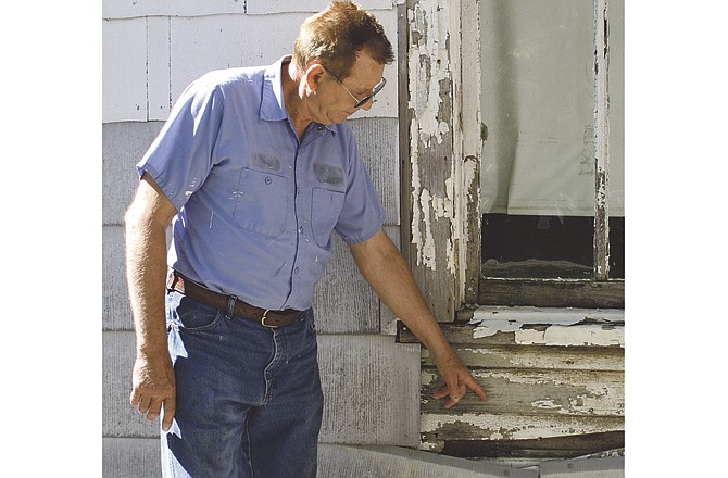 Portland resident Paul Mize indicates how high the flood waters reached at his mother's home in 1993. Two to three feet of water stood in the house for up to two weeks.