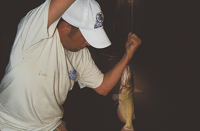 Shane Upchurch of Union City, Tenn., uses a yo-yo to bring in a fish on Reelfoot Lake in northwest Tennessee. 