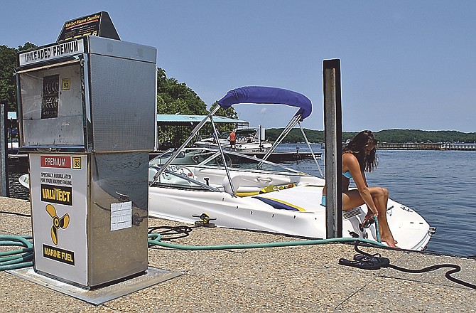 Sierra Wickham gases up Tim Castles' boat at the dock of Mariner Pier 31 at the Lake of the Ozarks near Camdenton, Mo.