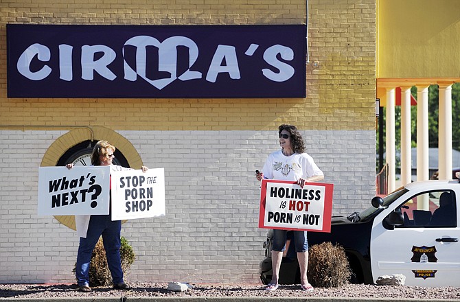 Julie Ruengert, left, and Jan Kruse stand on the public right of way Tuesday to protest a new business, Cirilla's, on Missouri Boulevard.