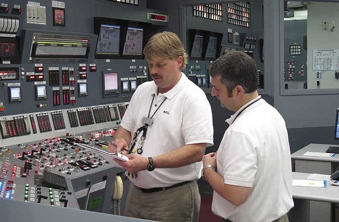 In this March 30, 2011 file photo, nuclear reactor operators Chris Heinz, left, and Roger Patterson check steps that need to be taken as they practice an emergency scenario on a simulator of a digital control panel at Oconee Nuclear Station in Seneca , S.C. The nuclear plant will be the first in the U.S. to install an all-digital control panel for one of its reactors.