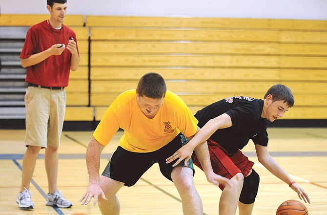 Assistant coach John Bernskoetter (background) keeps an eye on Steven Gunn (left) and James Bernskoetter as they run through a drill Wednesday during Calvary Lutheran's basketball camp at Trinity Lutheran. 