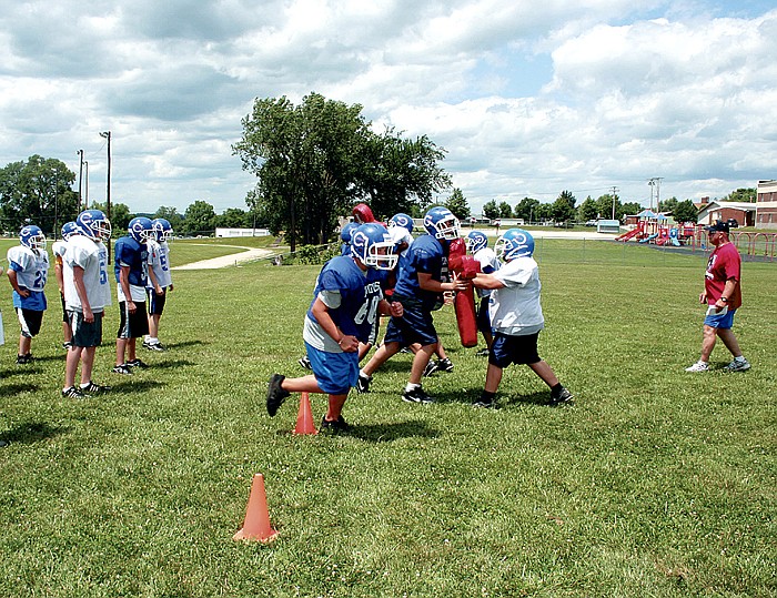 CMS Coach Ed Ziegs works on blocking with the boys.